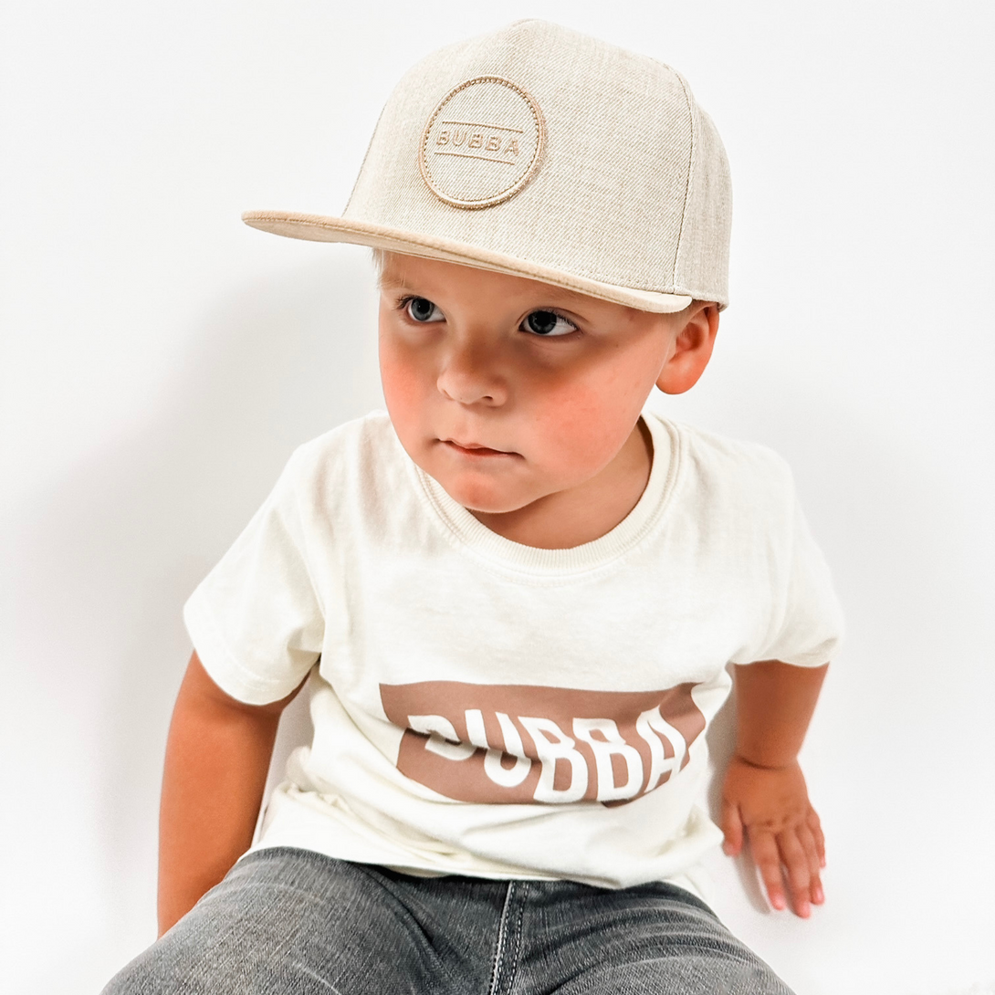 Tan Kids Trucker Hat with Bubba Logo: A stylish tan-colored children's trucker hat featuring a playful Bubba logo embroidered on the front.