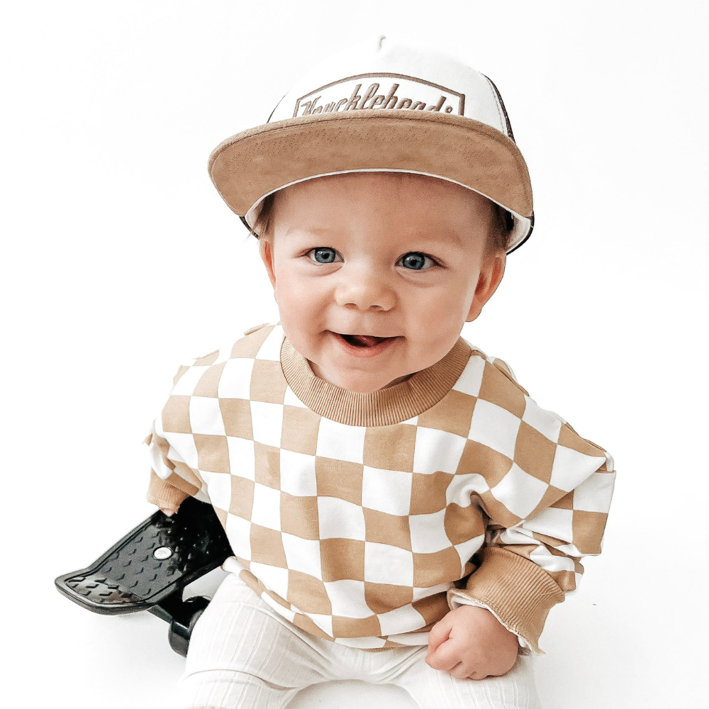 A photo showcasing a variety of vibrant kids trucker hats with playful designs, perfect for your child's outdoor adventures. These hats feature a mesh back for breathability and a classic trucker hat design, made for kids ages 2-7. Choose from a range of colors and designs to find the perfect hat for your little one.