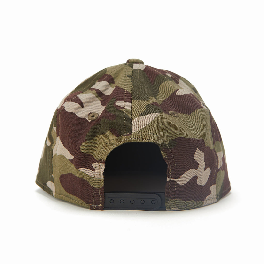 Image of Camo Kids Trucker Hat with Gold Rectangle Knuckleheads Patch: A rugged and stylish accessory designed for kids. In a classic camo pattern, it features a distinctive gold rectangle Knuckleheads patch on the front. Elevate your child's style with this fashionable hat, perfect for adding a touch of outdoor charm to their outfits.