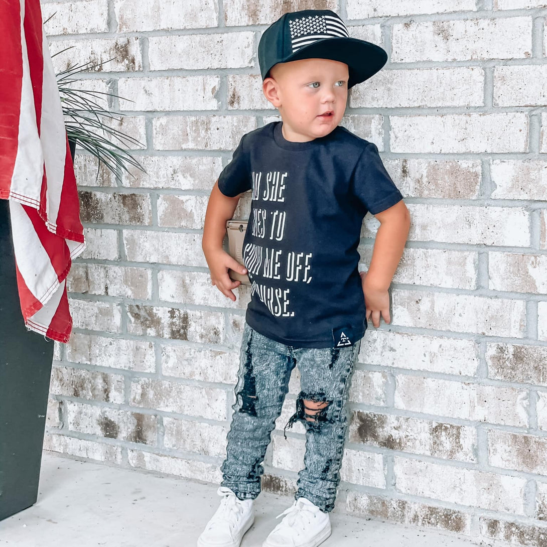 Image of Black Kids Trucker Hat with USA Flag Patch: A patriotic and stylish accessory designed for kids. In classic black, it features a prominent USA flag patch on the front. Elevate your child's style with this fashionable hat, perfect for adding a touch of national pride to their outfits. Crafted with care, this black kids trucker hat with the USA flag patch is a must-have addition to their wardrobe, suitable for various occasions and everyday wear.