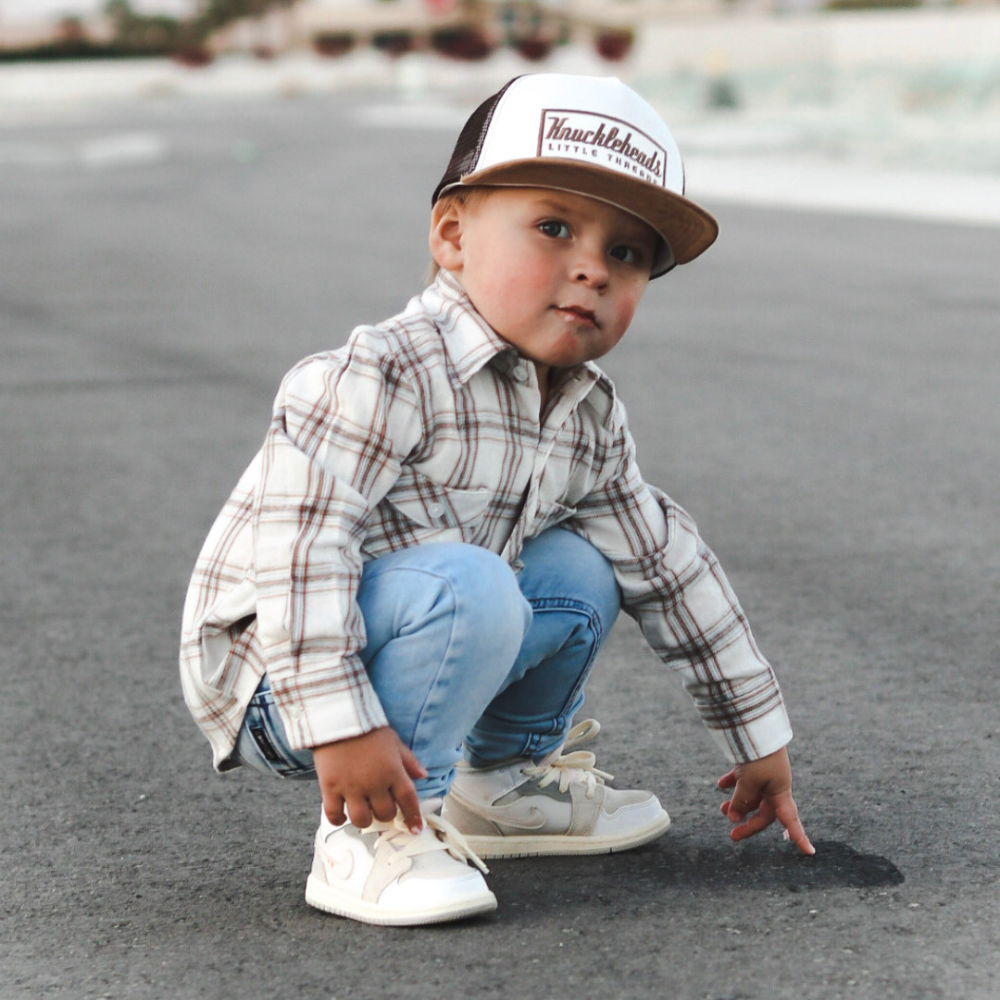 A photo showcasing a variety of vibrant kids trucker hats with playful designs, perfect for your child's outdoor adventures. These hats feature a mesh back for breathability and a classic trucker hat design, made for kids ages 2-7. Choose from a range of colors and designs to find the perfect hat for your little one.