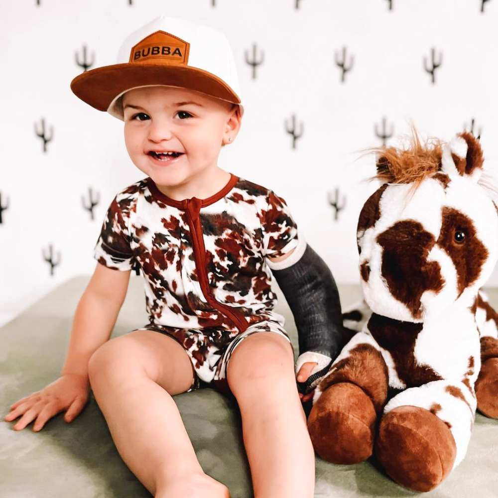 Image of White and Brown Kids Trucker Hat with 'Bubba' Patch: A charming and stylish accessory designed for kids. Combining fresh white and warm brown tones, it features a playful 'Bubba' patch on the front. Elevate your child's style with this fashionable hat, perfect for adding a touch of contrast to their outfits. Crafted with care, this white and brown kids trucker hat with the 'Bubba' patch is a must-have addition to their wardrobe, suitable for various occasions and everyday wear.