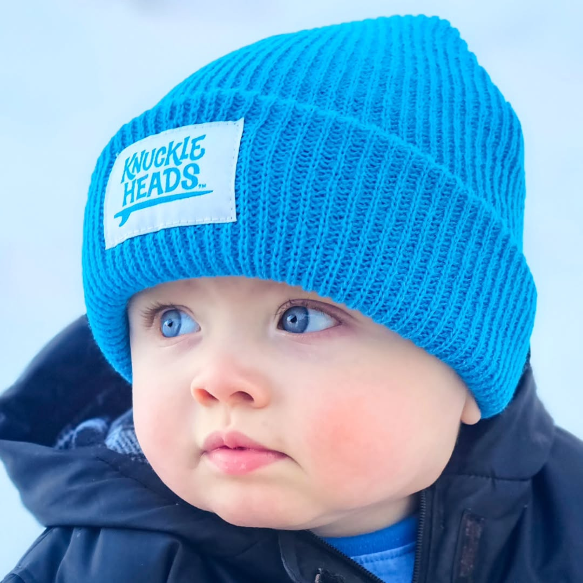 Baby winter hat in electric blue ribbed knit with folded cuff and Knuckleheads label