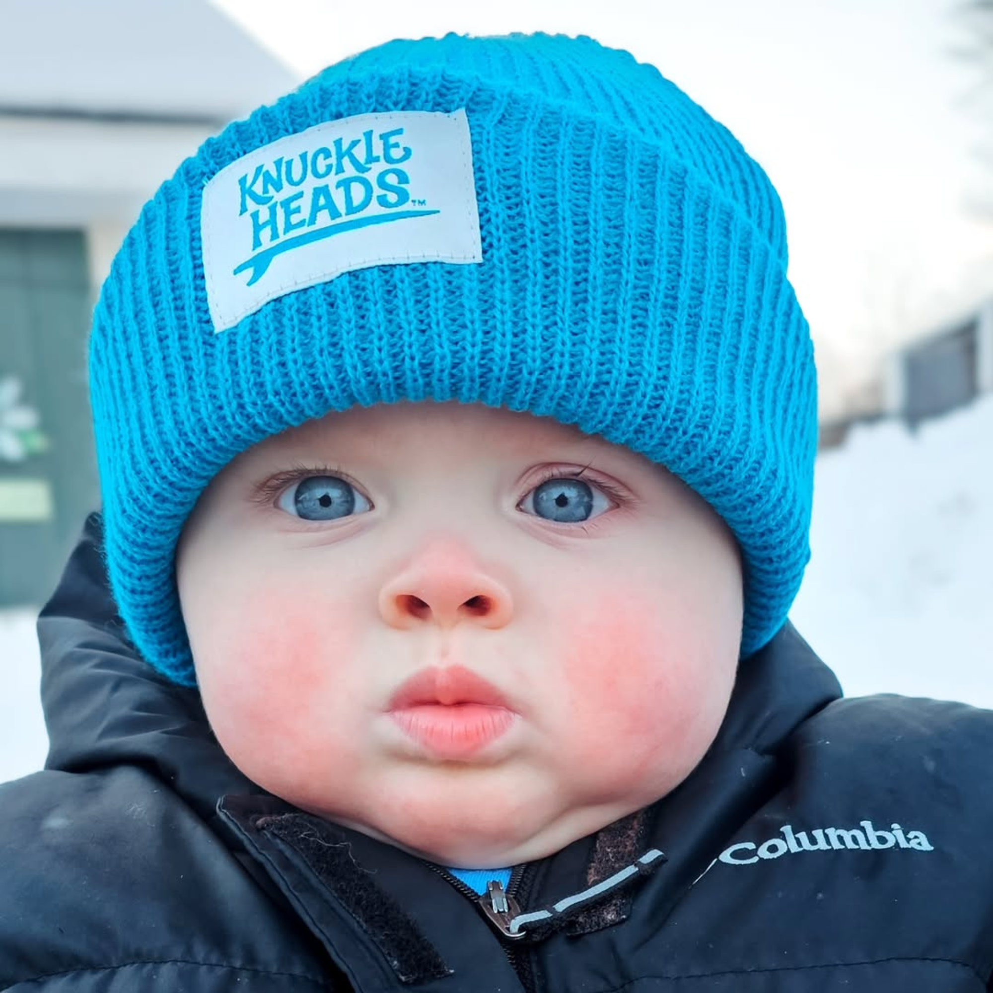 Baby winter hat in electric blue ribbed knit with folded cuff and Knuckleheads label