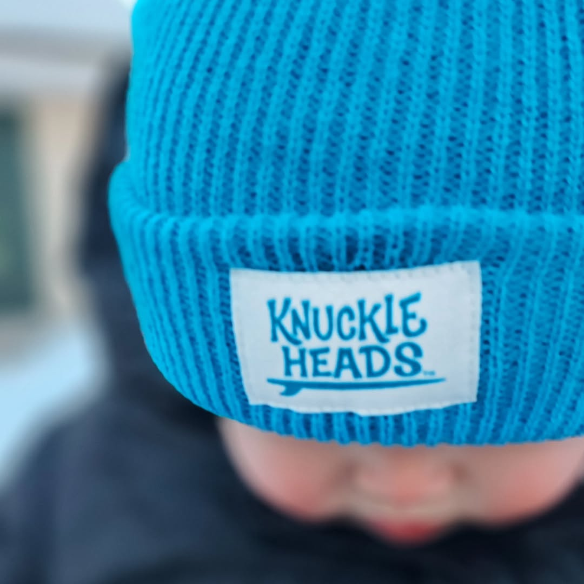 Baby winter hat in electric blue ribbed knit with folded cuff and Knuckleheads label