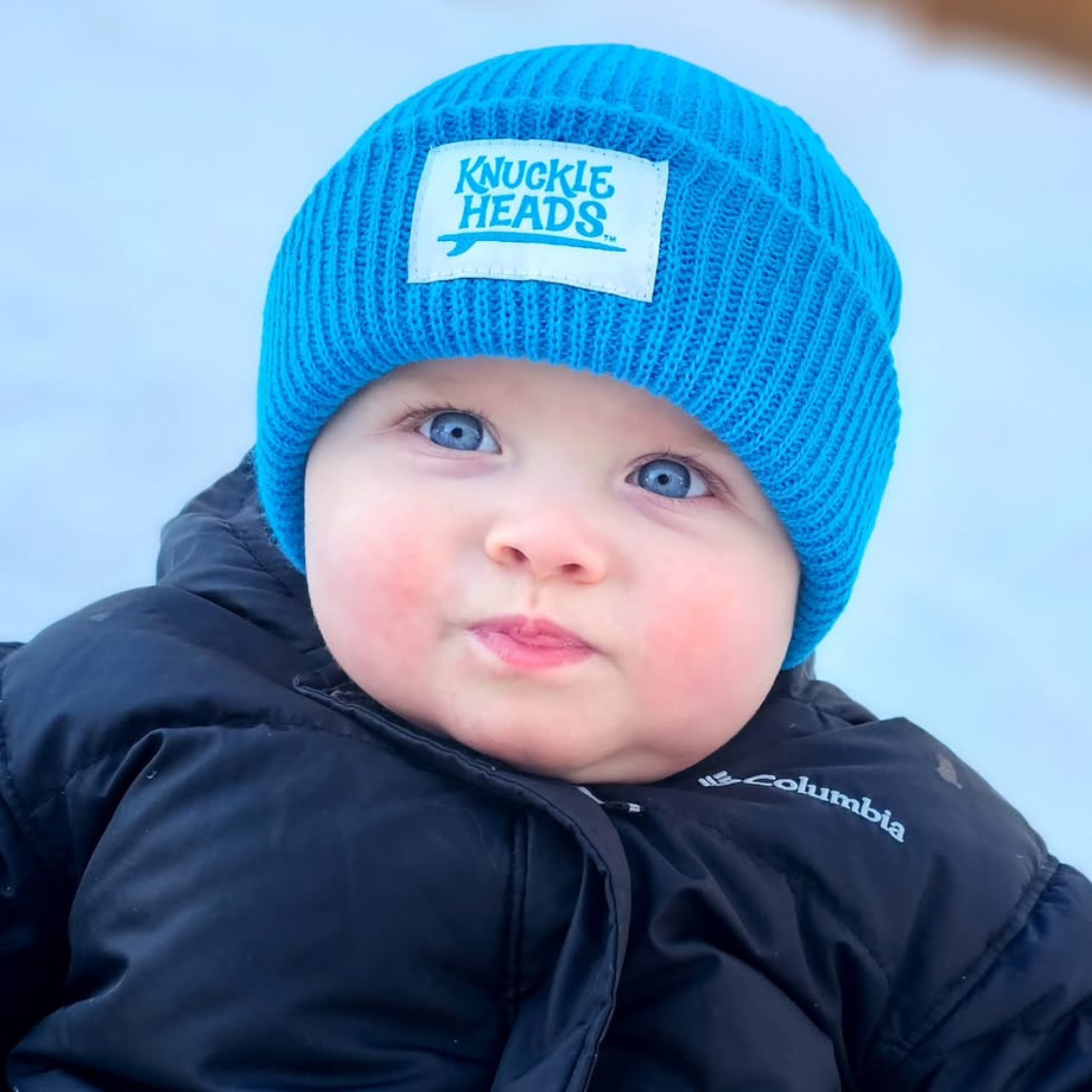 Baby winter hat in electric blue ribbed knit with folded cuff and Knuckleheads label
