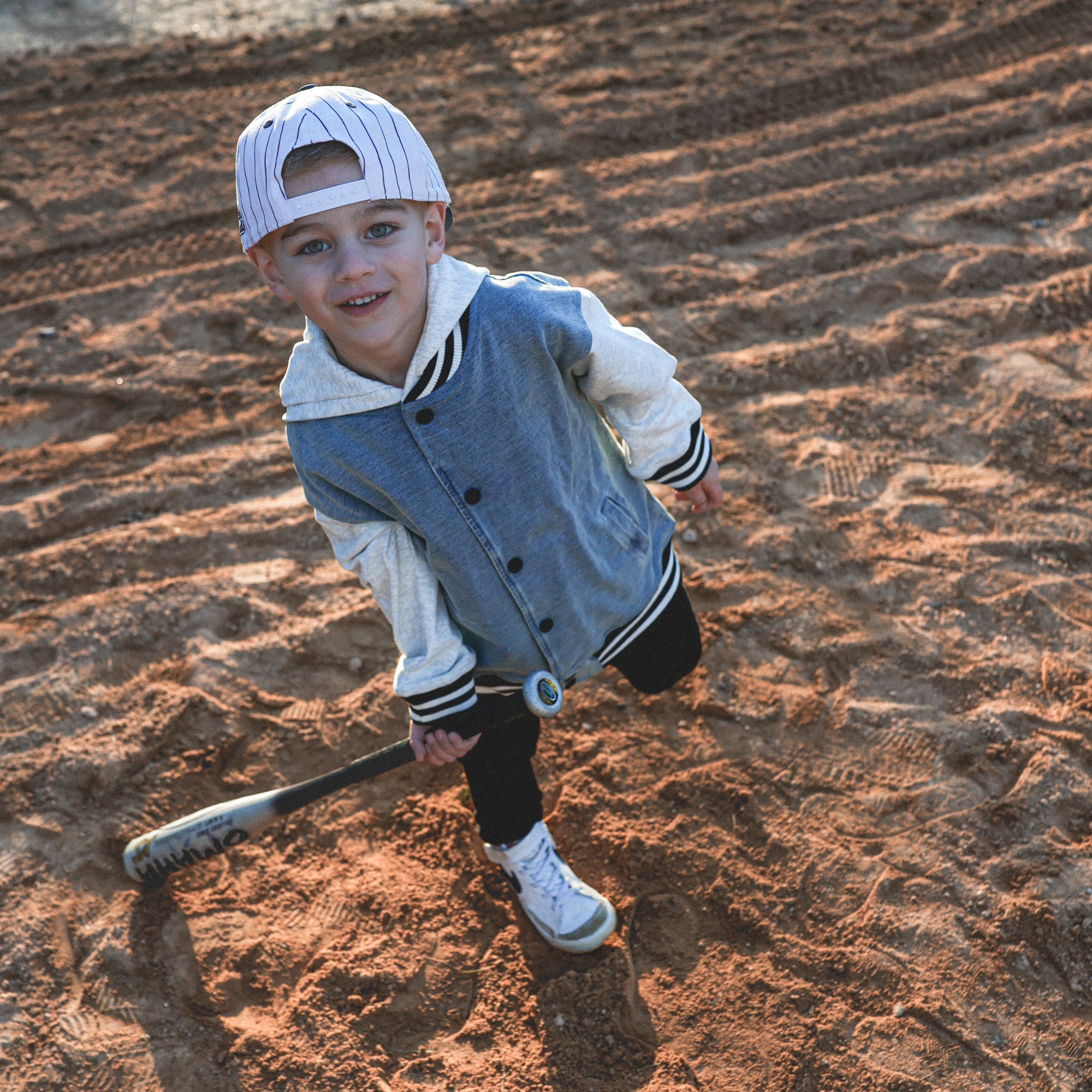 Lifestyle photo of toddler wearing Bubba embroidered snapback hat with navy pinstripes outdoors