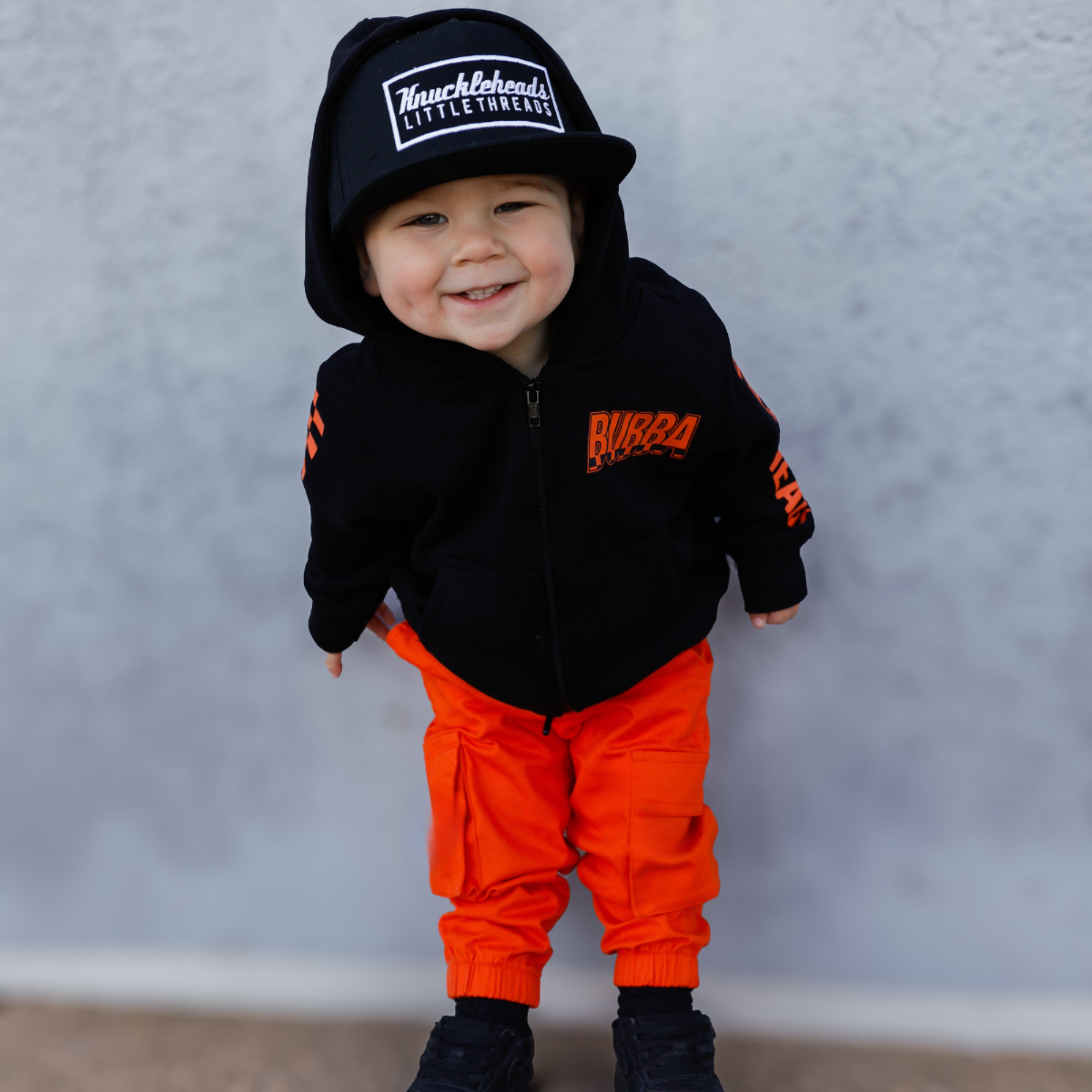 Knuckleheads Kids Bubba Zip Hoodie black graphic sweatshirt with orange logo and checker sleeves for toddlers and youth