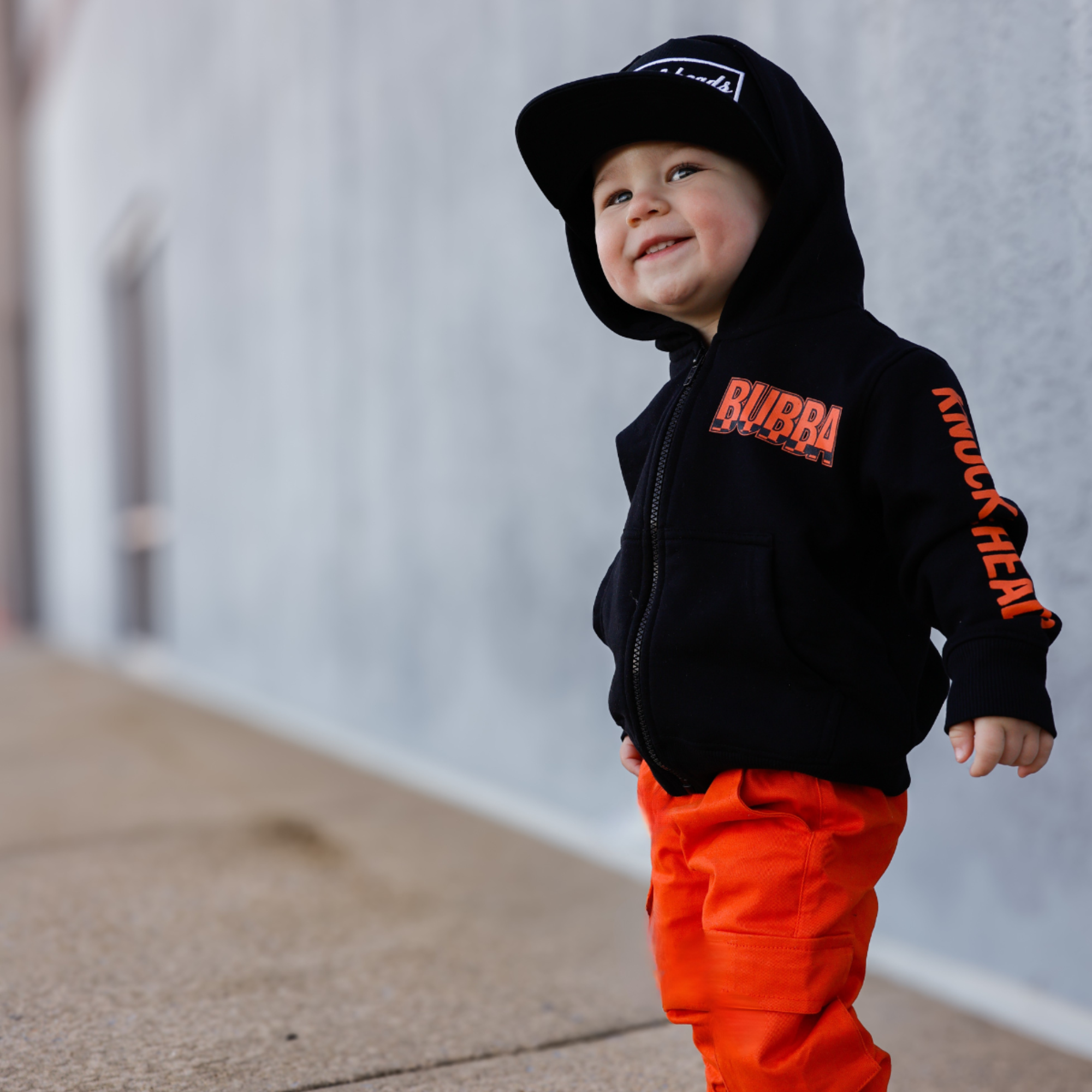 Knuckleheads Kids Bubba Zip Hoodie black graphic sweatshirt with orange logo and checker sleeves for toddlers and youth