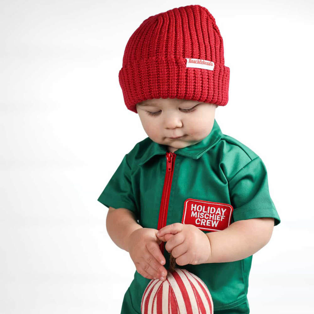 Holiday-themed toddler coverall in bright green with a red zipper and “Holiday Mischief Crew” patch, giving a playful mechanic look perfect for Christmas photos and adventures