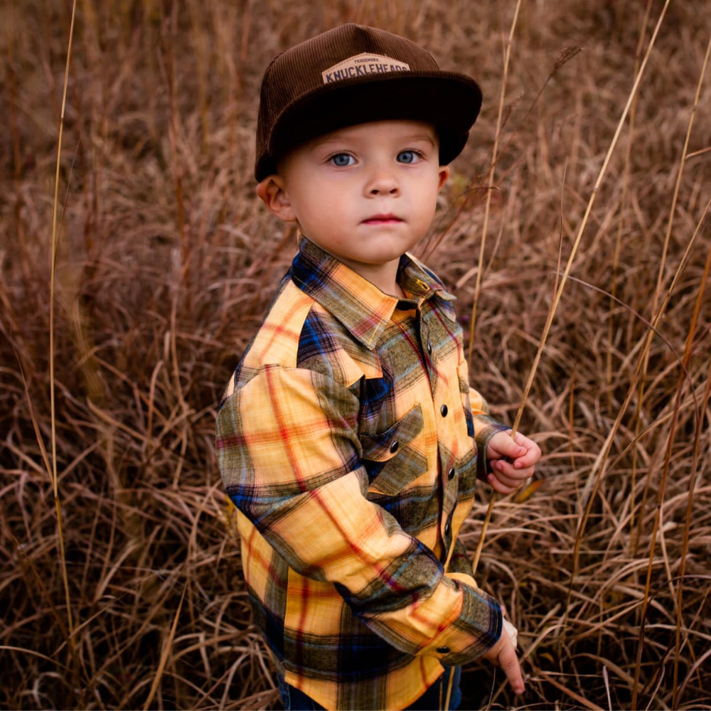 Introducing the 'Brayden' Brown Corduroy Kids Trucker Hat with Knuckleheads Patch: A trendy and stylish accessory tailored for kids. Crafted with a rich brown corduroy fabric, it showcases a cool Knuckleheads patch on the front. Elevate your child's style with this fashionable hat, perfect for adding texture to their outfits. Whether for outdoor escapades or everyday wear, the 'Brayden' brown corduroy trucker hat with Knuckleheads patch is a must-have addition to their wardrobe.