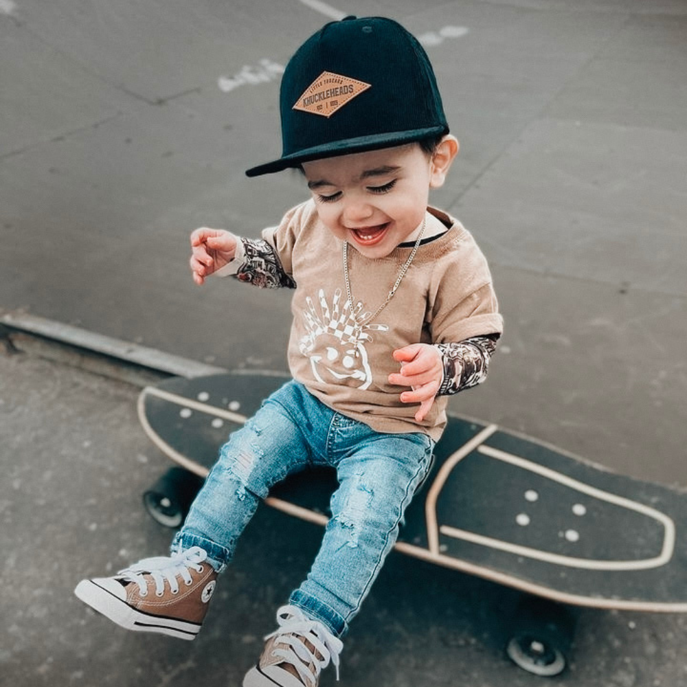 Image of Tan Kids T-Shirt with Knuckleheads Logo: A stylish and versatile addition to kids' wardrobes. This tan-colored t-shirt features the iconic Knuckleheads logo on the front. Keep your child's style on point with this comfortable shirt, perfect for adding a touch of character to their outfits.