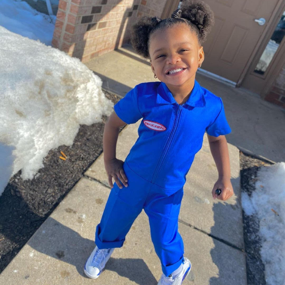 This image showcases delightful blue kids' coveralls adorned with a charming Knuckleheads patch, adding a touch of whimsy to your child's wardrobe. These coveralls are not only fashionable but also comfortable, making them an ideal choice for your little one's everyday adventures.