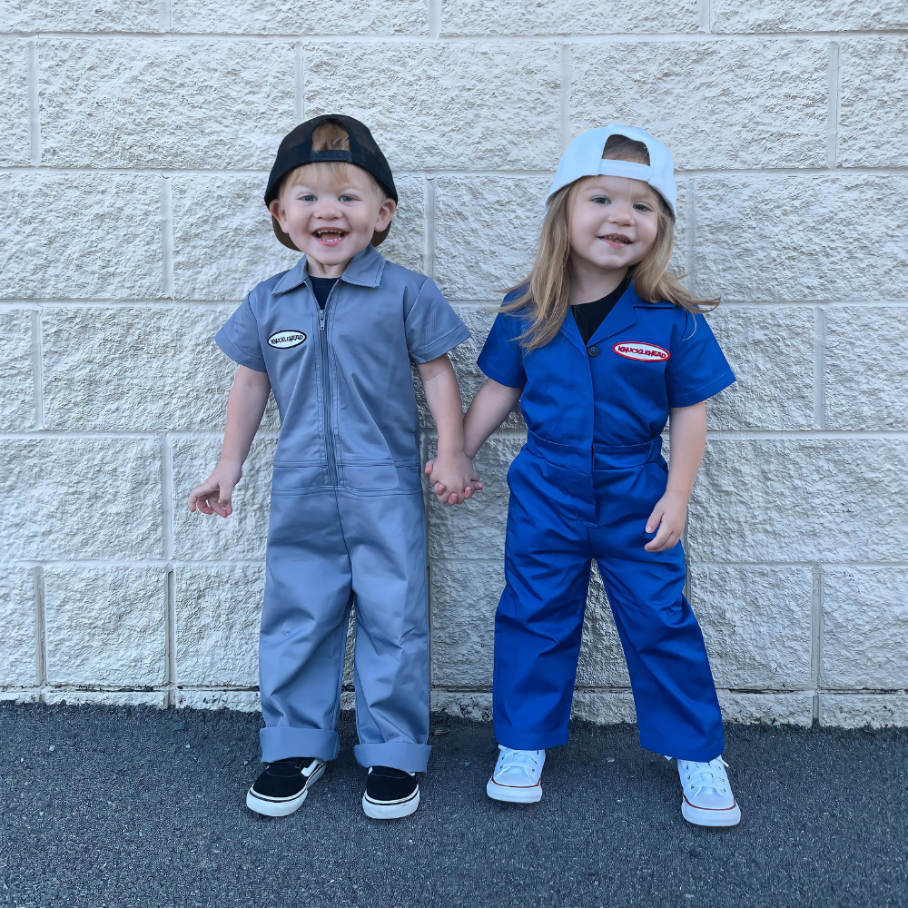 This image showcases delightful grey kids' coveralls adorned with a charming Knuckleheads patch, adding a touch of whimsy to your child's wardrobe. These coveralls are not only fashionable but also comfortable, making them an ideal choice for your little one's everyday adventures.