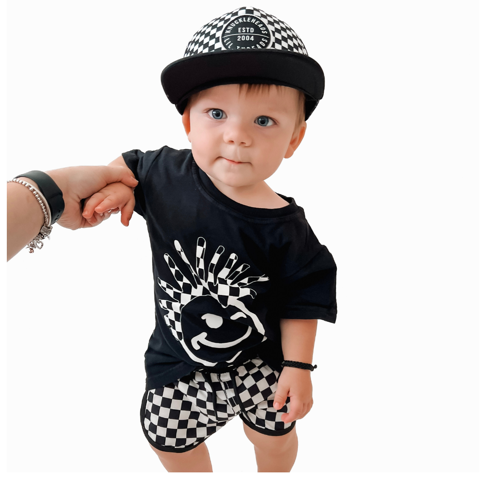 Get your kids ready for a day of water fun with these stylish swim shorts in a classic white and black checkered pattern. The shorts showcase the Knuckleheads logo, adding a touch of attitude to their beach or poolside look. The contrasting colors and distinctive logo make these swim shorts a trendy and playful choice for young adventurers enjoying their summer escapades.