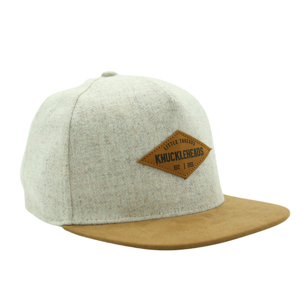 Image of Tan with Brown Bill Kids Trucker Hat with Knuckleheads Patch: A cool and trendy trucker hat designed for kids. The hat features a stylish tan crown and a brown bill, adorned with a striking Knuckleheads patch on the front. Elevate your child's style with this fashionable and comfortable accessory, perfect for any adventure or everyday wear. Crafted with care, this black with brown bill trucker hat with a Knuckleheads patch is a must-have addition to their wardrobe.