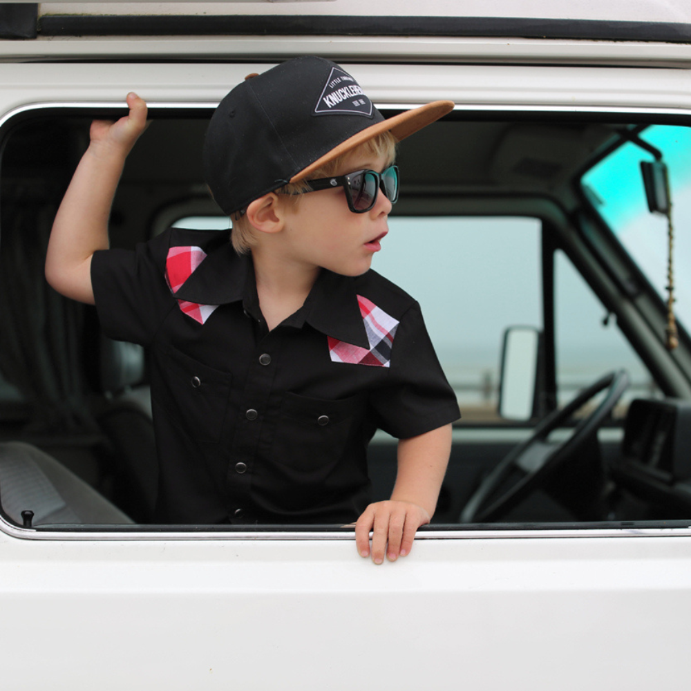 Image of Black and Brown Kids Trucker Hat with Knuckleheads Patch: A stylish and versatile accessory designed for kids. Combining sleek black and warm brown tones, it features a striking Knuckleheads patch on the front. Elevate your child's style with this fashionable hat, perfect for adding a touch of contrast to their outfits.
