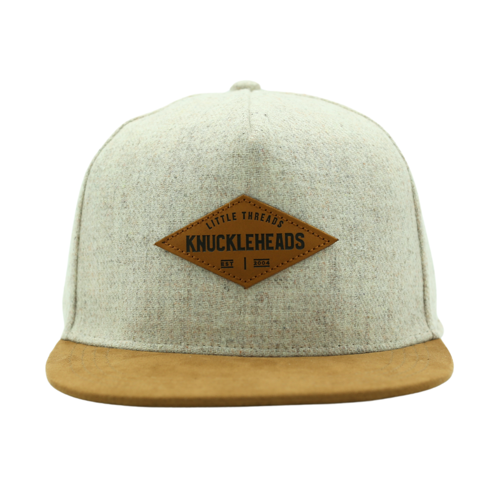 Image of Tan with Brown Bill Kids Trucker Hat with Knuckleheads Patch: A cool and trendy trucker hat designed for kids. The hat features a stylish tan crown and a brown bill, adorned with a striking Knuckleheads patch on the front. Elevate your child's style with this fashionable and comfortable accessory, perfect for any adventure or everyday wear. Crafted with care, this black with brown bill trucker hat with a Knuckleheads patch is a must-have addition to their wardrobe.