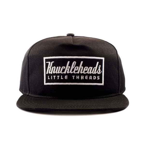 Image of Black Kids Trucker Hat with Knuckleheads Patch: A trendy and versatile accessory designed for kids. In classic black, it showcases a striking Knuckleheads patch on the front. Elevate your child's style with this fashionable hat, perfect for adding a touch of character to their outfits. Crafted with care, this black kids trucker hat with the Knuckleheads patch is a must-have addition to their wardrobe, suitable for various occasions and everyday wear.