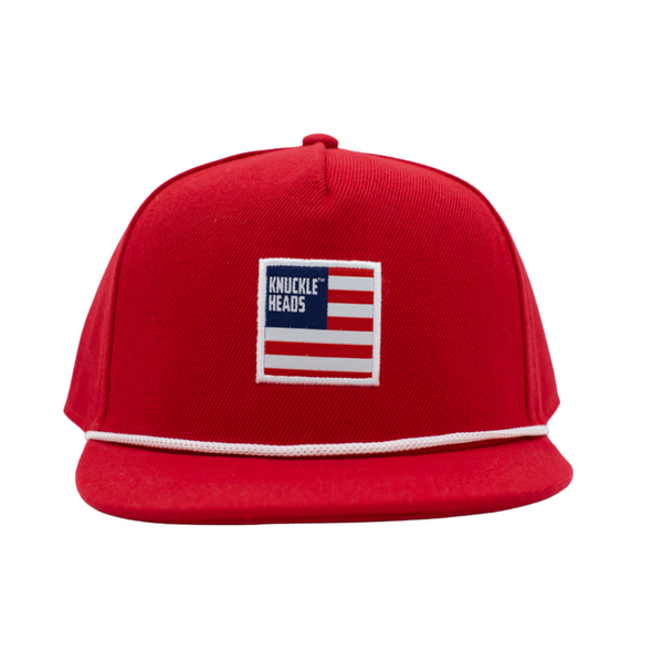 Image of Red USA Kids Trucker Hat with Knuckleheads USA Flag Patch: A patriotic and stylish trucker hat designed for kids. The hat comes in vibrant red and showcases a striking USA flag patch by Knuckleheads on the front. Made with no sun mesh for a comfortable and breathable wear. Perfect accessory to elevate your child's style while proudly showing their American spirit and providing sun protection.