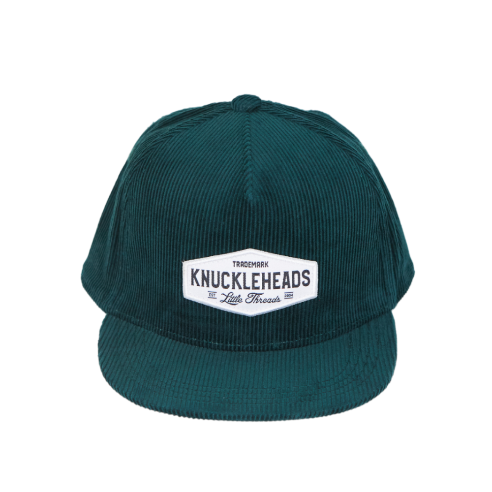 Image of Green Corduroy Kids Trucker Hat with Knuckleheads Patch: A vintage-inspired and stylish accessory designed for kids. In a rich green corduroy fabric, it showcases a striking Knuckleheads patch on the front. Elevate your child's style with this fashionable hat, perfect for adding a touch of texture to their outfits.
