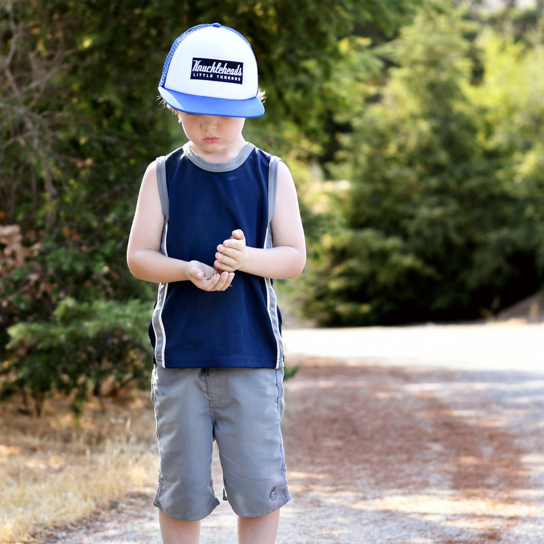 Image of Blue Kids Trucker Hat with White Mesh and Knuckleheads Patch: A trendy and practical accessory designed for kids. In a vibrant blue hue with crisp white mesh, it showcases a striking Knuckleheads patch on the front. Elevate your child's style with this fashionable hat, perfect for adding a pop of color to their outfits while ensuring breathability. 