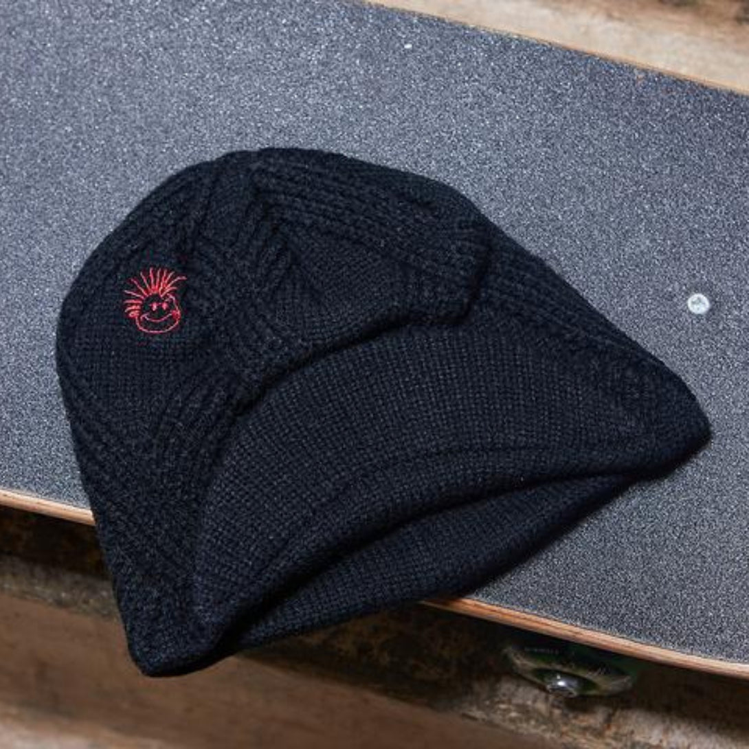 Close-up photo of a stylish black beanie designed for kids. The beanie features a classic Knuckleheads tag and a small visor, adding a touch of vintage flair to the modern design.