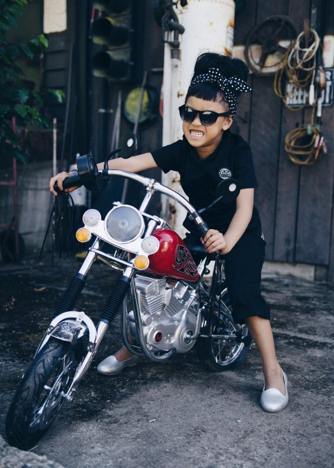 This image showcases delightful black kids' coveralls adorned with a charming Knuckleheads patch, adding a touch of whimsy to your child's wardrobe. These coveralls are not only fashionable but also comfortable, making them an ideal choice for your little one's everyday adventures.