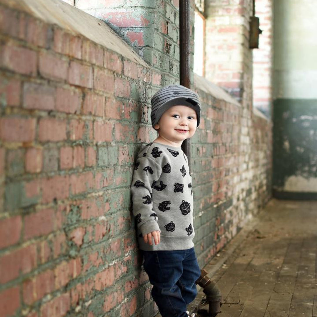 Image featuring a grey beanie with a visor and skull patterns, designed for children. This versatile beanie merges practicality with style, offering both a visor and edgy skull patterns. Perfect for infants and toddlers, it stands out within the collection of Infant hats, providing a unique combination of functionality and charm.