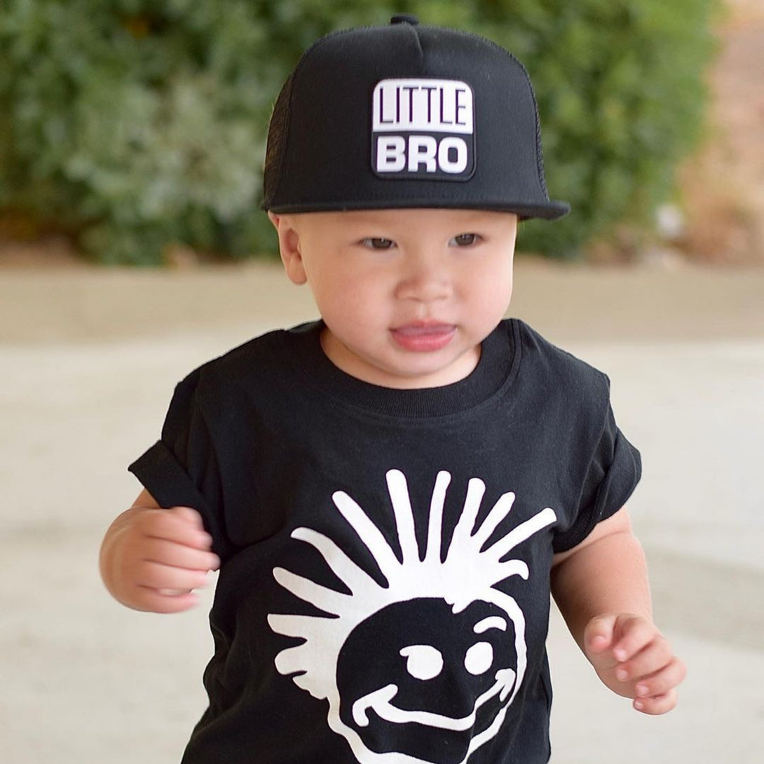 Image of Black Kids Trucker Hat with 'Little Bro' Patch: A trendy and stylish accessory designed for kids. In classic black, it features an adorable 'Little Bro' patch on the front. Elevate your child's style with this fashionable hat, perfect for adding a playful touch to their outfits. Crafted with care, this black kids trucker hat with the 'Little Bro' patch is a must-have addition to their wardrobe, suitable for various occasions and everyday wear.