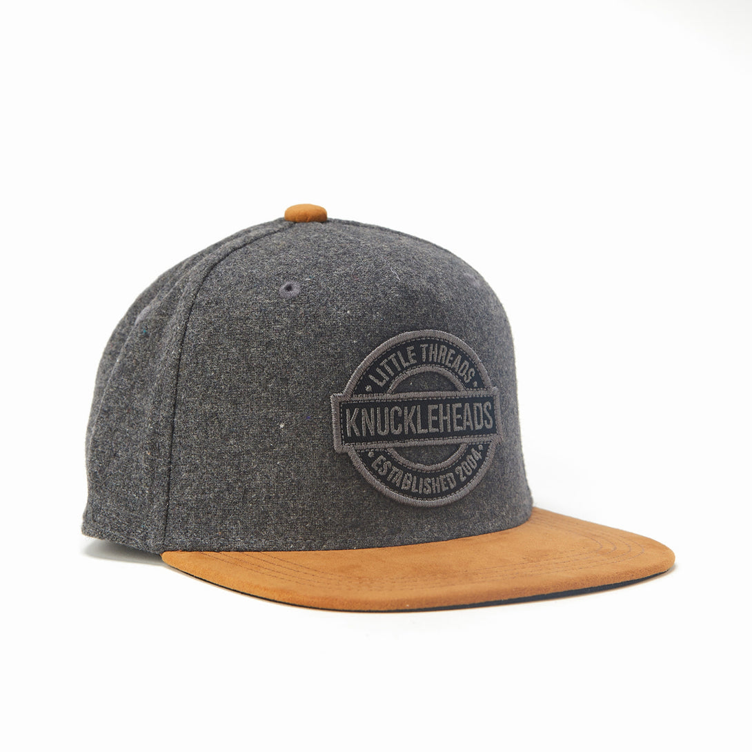 Image of Oat and Brown Kids Trucker Hat with Knuckleheads Patch: A rustic and stylish accessory designed for kids. In a charming oat and brown color combination, it showcases a striking Knuckleheads patch on the front. Elevate your child's style with this fashionable hat, perfect for adding a touch of natural flair to their outfits.