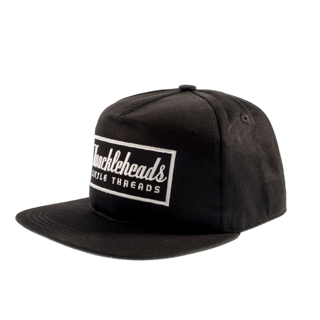 Image of Black Kids Trucker Hat with Knuckleheads Patch: A trendy and versatile accessory designed for kids. In classic black, it showcases a striking Knuckleheads patch on the front. Elevate your child's style with this fashionable hat, perfect for adding a touch of character to their outfits. Crafted with care, this black kids trucker hat with the Knuckleheads patch is a must-have addition to their wardrobe, suitable for various occasions and everyday wear.