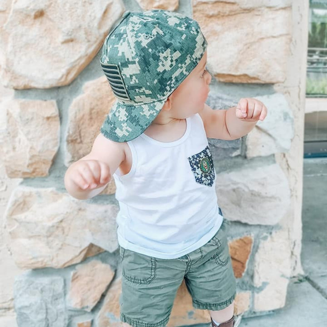 Image of Camo Kids Trucker Hat with USA Flag Patch: A patriotic and stylish accessory designed for kids. In a captivating camo pattern, it features a prominent USA flag patch on the front. Elevate your child's style with this fashionable hat, perfect for adding a touch of national pride to their outfits.