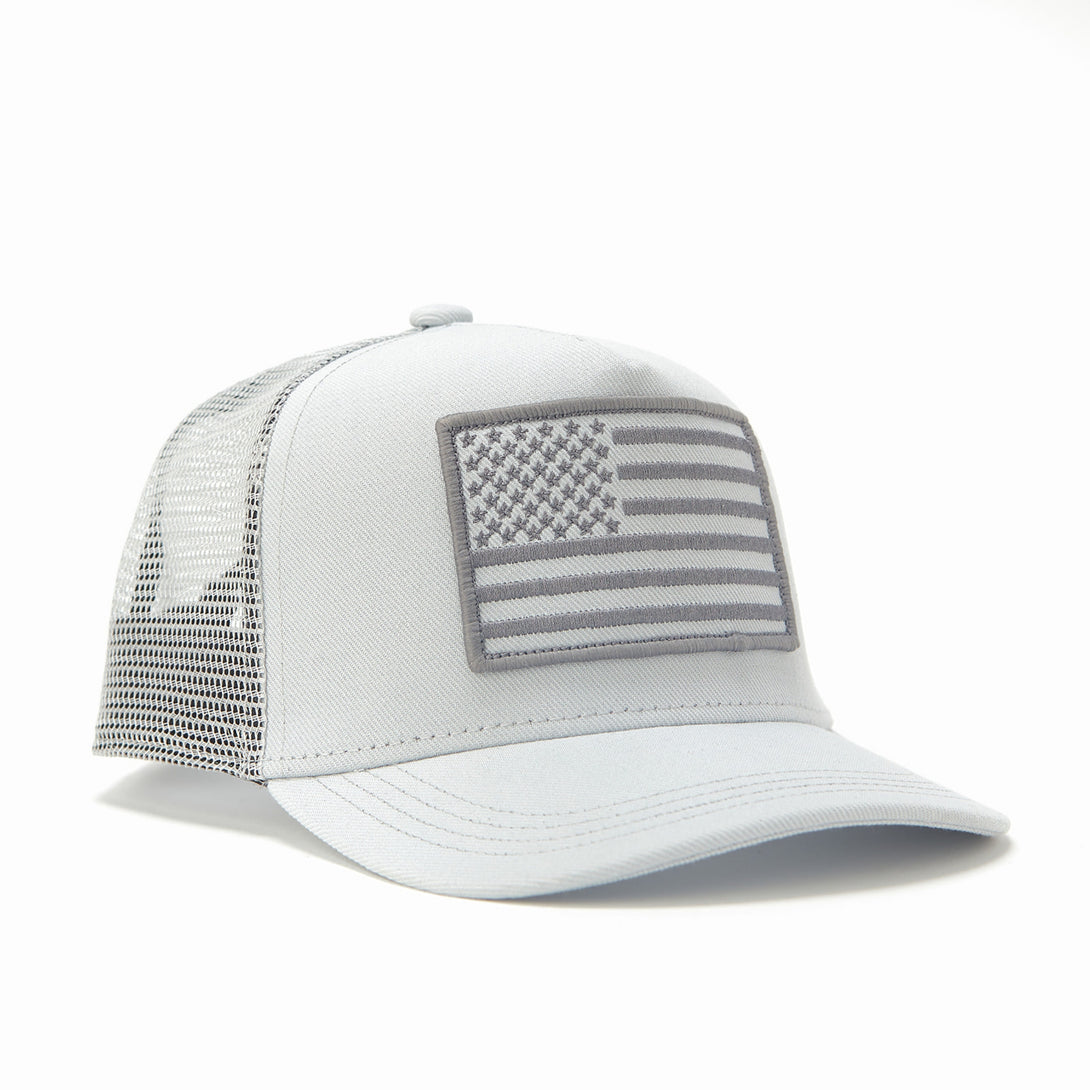 "Image of Kids Trucker Hat with White Mesh and USA Flag Patch: A patriotic and stylish accessory designed for kids. In clean white with matching white mesh, it features a prominent USA flag patch on the front. Elevate your child's style with this fashionable hat, perfect for adding a touch of national pride to their outfits while ensuring breathability. 