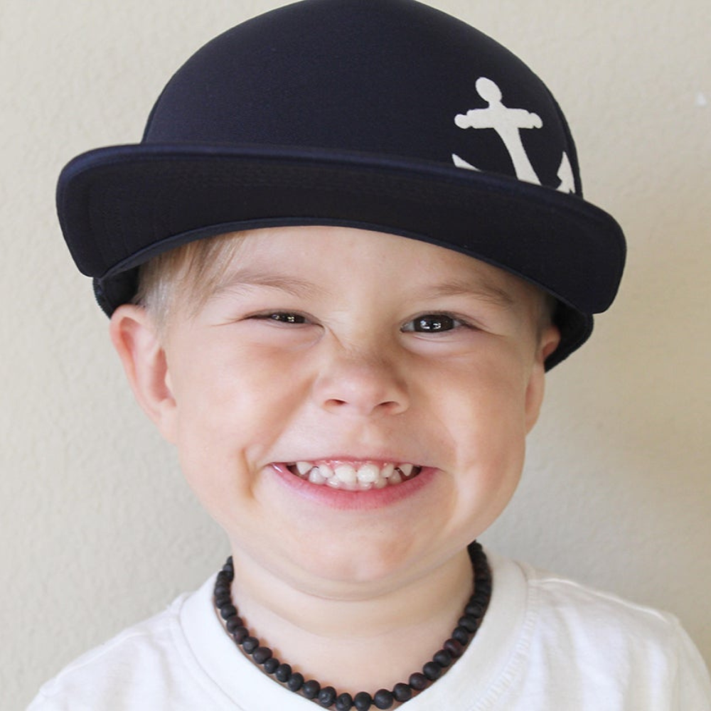 Presenting the Navy Kids Trucker Hat with Anchor Patch and Sun Mesh: A nautical and stylish headwear choice designed for kids. In a timeless navy hue, it features a charming anchor patch on the front and sun mesh for added comfort. Elevate your child's style with this fashionable and practical accessory, ideal for outdoor adventures and everyday wear. Crafted meticulously, this navy trucker hat with the anchor patch and sun mesh is a must-have addition to their wardrobe.