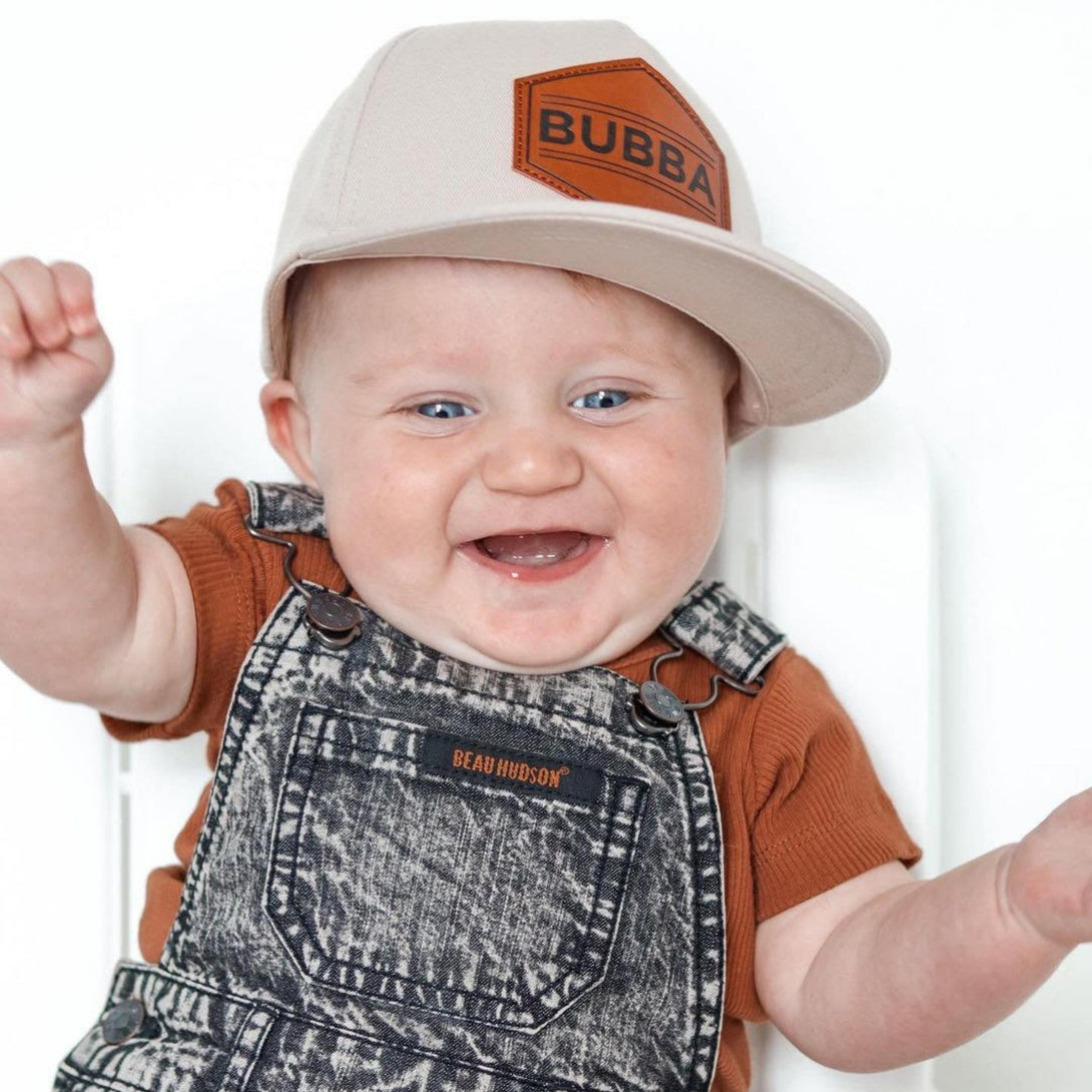 Image of White Kids Trucker Hat with 'Bubba' Patch: A stylish and versatile accessory designed for kids. In crisp white, it features a playful 'Bubba' patch on the front. Elevate your child's style with this fashionable hat, perfect for adding a touch of flair to their outfits. Crafted with care, this white kids trucker hat with the 'Bubba' patch is a must-have addition to their wardrobe, suitable for various occasions and everyday wear.