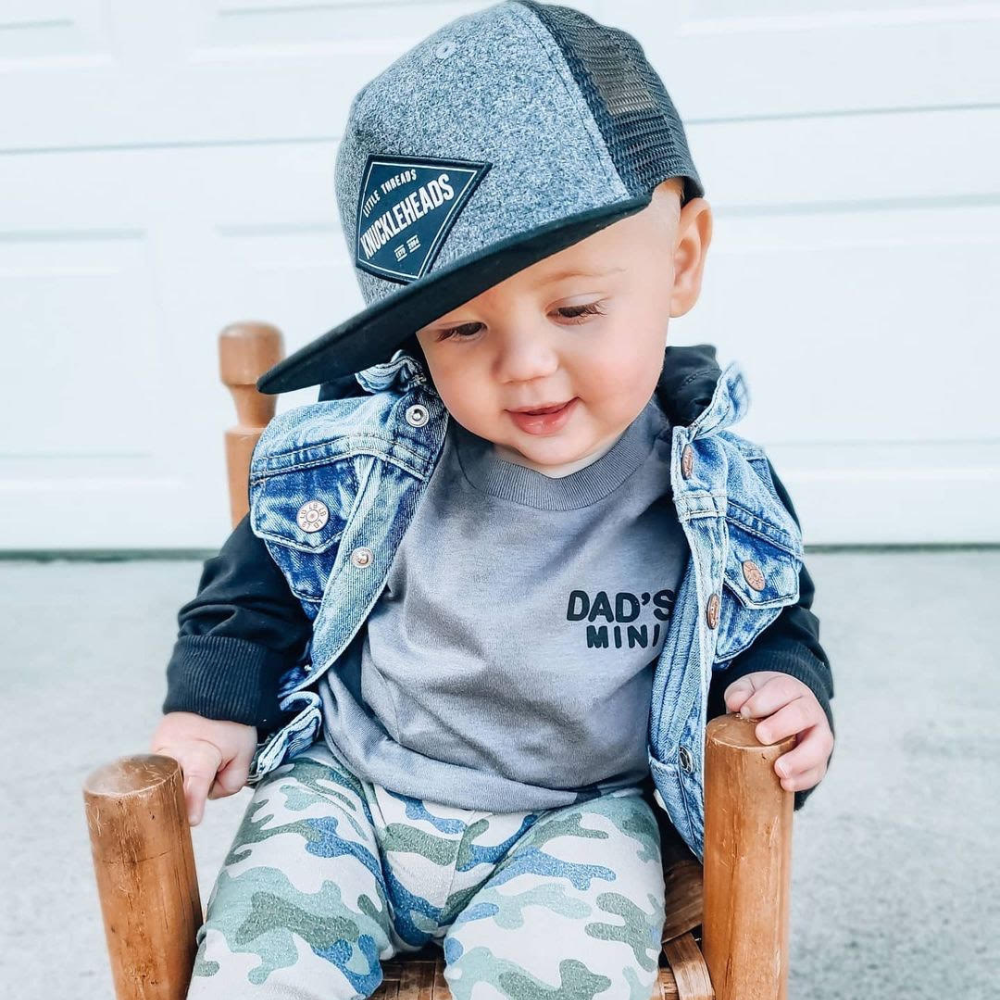 Image of Grey Kids Trucker Hat with Black Mesh and Knuckleheads Patch: A modern and stylish accessory designed for kids. In sleek grey with contrasting black mesh, it showcases a striking Knuckleheads patch on the front. Elevate your child's style with this fashionable hat, perfect for adding a touch of contrast to their outfits while ensuring breathability. 