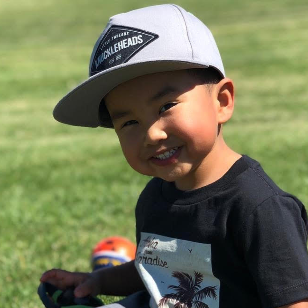 Image of Grey Kids Trucker Hat with Knuckleheads Patch: A versatile and stylish accessory designed for kids. In sleek grey, it showcases a striking Knuckleheads patch on the front. Elevate your child's style with this fashionable hat, perfect for adding a touch of character to their outfits.
