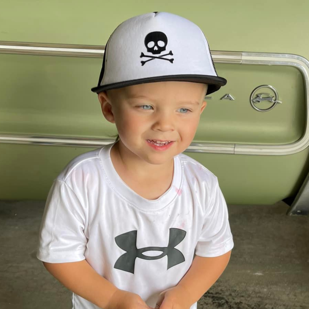 "Image of Black and White Kids Trucker Hat with Black Mesh and Skull Patch: A bold and stylish accessory designed for kids. In a classic black and white combination with black mesh, it features a striking skull patch on the front. Elevate your child's style with this fashionable hat, perfect for adding a touch of edgy flair to their outfits. 