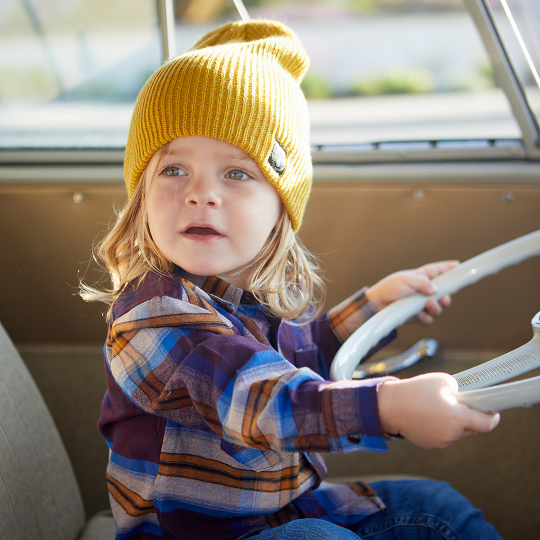 Image highlighting a vibrant yellow beanie from Knuckleheads, designed for children. This versatile beanie, complete with the Knuckleheads brand tag, offers a classic style suitable for infants and toddlers. A cheerful addition to the collection of Infant hats, adding a bright touch of charm.